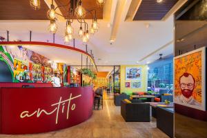 曼谷曼谷易思廷大酒店沙吞的餐厅设有红色柜台和桌椅
