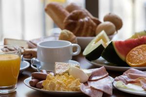 巴塞罗那四国酒店的餐桌上摆放着早餐食品和橙汁盘