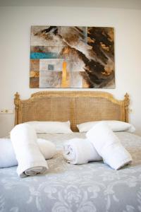 塔里法Penthouse Tarifa with Sea Views的一张带毛巾和绘画的床