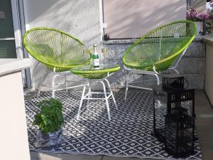 农嫩霍恩Ferienwohnung im Fischerhaus的庭院配有两把绿色椅子和一张桌子