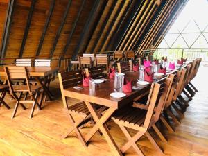 阿努拉德普勒Lolu Village Resort的一张长桌,上面有粉红色的餐巾