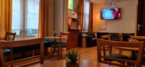 阿姆斯特丹尤菲米娅老城区运河区廉价酒店的客厅配有桌椅和电视。