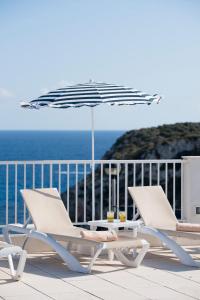 卡拉恩波特Seth Playa Azul的两把椅子和一把遮阳伞,位于一个享有海景的甲板上