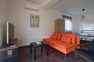 奥米沙利Apartman Studio Pesja的客厅配有橙色沙发和床。