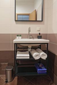 奥米沙利Apartman Studio Pesja的一间带水槽、毛巾和镜子的浴室