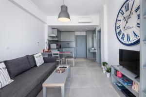 科斯镇Milva Apartments的客厅配有沙发和墙上的时钟