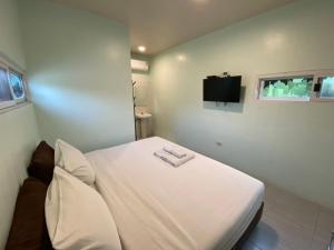 北碧Makan Resort的带电视的客房内的一张白色床