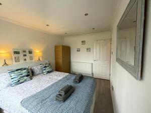 齐格威尔Stylish Flat 2 Bedroom with Free Wifi & Parking Chigwell Epping London的一间卧室配有一张床,上面有两条毛巾