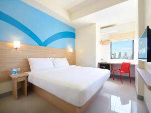 宿务Hop Inn Hotel Cebu City的卧室配有白色的床和红色椅子