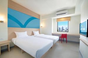宿务Hop Inn Hotel Cebu City的一间酒店客房,设有两张床和电视