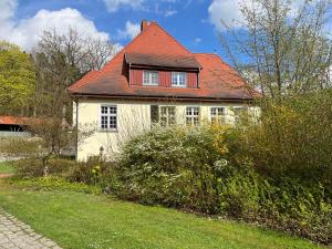 滨湖克拉科Gästezimmer für Naturliebhaber的一间白色的小房子,有红色的屋顶