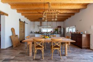 维多利亚Casa di Noi的厨房以及带木桌和椅子的用餐室。