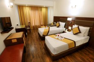 瓦拉纳西梅雷德大酒店的酒店客房设有两张床和一张桌子。