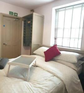 伯恩利Turner - En-suite Room in Canalside Guesthouse的一间房间,床上有红色枕头