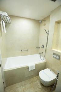 瓦拉纳西梅雷德大酒店的带浴缸和卫生间的浴室。