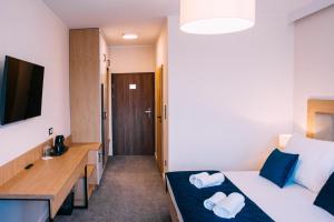 TopólkaJesionowa Noclegi的酒店客房配有两张床和一张书桌
