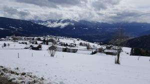 马兰扎Pension Marianne的一座白雪覆盖的村庄,后面有群山