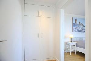 博尔滕哈根Dünenblick Wohnung 51的卧室内的白色衣柜,配有一张床