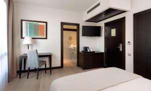 卡塔赫纳Hotel Cartagena Puerto的酒店客房配有一张床和一张带椅子的书桌