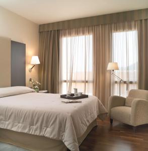 卡塔赫纳Hotel Cartagena Puerto的配有一张床和一把椅子的酒店客房
