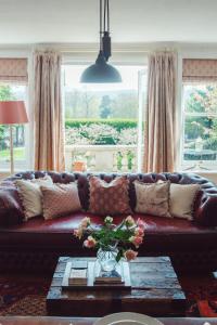 斯特雷特利Traditional 18th Century Farmhouse in Streatley的客厅配有带枕头的棕色皮沙发