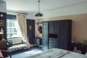 斯特雷特利Traditional 18th Century Farmhouse in Streatley的一间卧室配有一张床、一个梳妆台和一扇窗户。