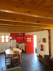 维拉多比斯坡Casa Pedralva的厨房配有桌子和红色的门