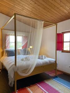 维拉多比斯坡Casa Pedralva的卧室配有带蚊帐的天蓬床