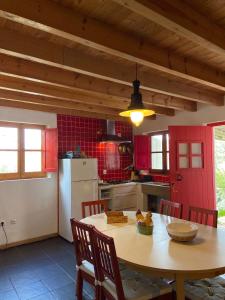 维拉多比斯坡Casa Pedralva的厨房配有桌子和红色的门