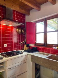 维拉多比斯坡Casa Pedralva的厨房设有墙壁上的红色瓷砖和炉灶。