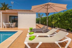 卡拉恩波特Villa Marina -Cala EnPorter-的别墅配有游泳池、草坪椅和遮阳伞