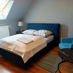 Wola KalinowskaWilla Różana的一间卧室配有蓝色的床和蓝色椅子