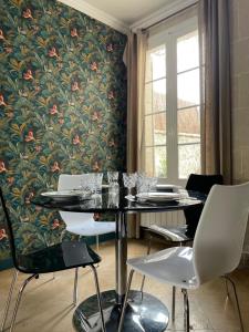 皮埃尔丰Gîte les Remparts的用餐室配有桌椅和花卉壁纸