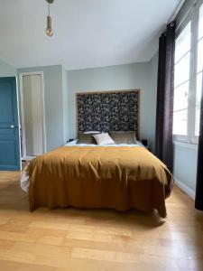 皮埃尔丰Gîte les Remparts的一间卧室配有一张大床和棕色床罩