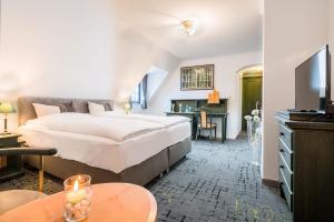 梅舍德BB Landhotel Hütter的酒店客房设有一张大床和一张书桌。