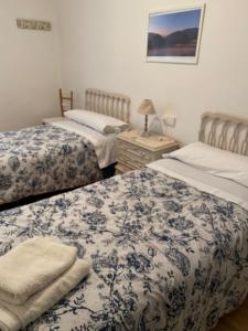 CamarasaHostal Casiano Camarasa的一间卧室配有两张带蓝白色床单的床