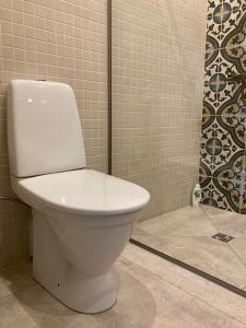 罗亚LUČI jūras apartamenti的带淋浴的浴室配有白色卫生间