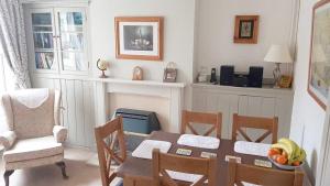谢林汉姆Mabel Cottage Sheringham的一间带桌椅的用餐室和一间带桌子的房间