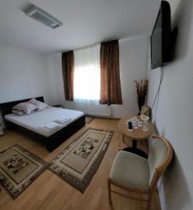 奥尔绍瓦Casa UILA的一间卧室配有一张床、一张桌子和一台电视。