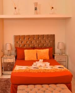 波特莫尔Caribbean estate deluxe 2的一间卧室配有一张带2晚台的橙色大床