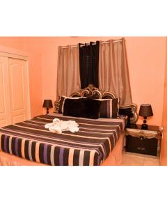 波特莫尔Caribbean estate deluxe 2的一间卧室配有一张带条纹毯子的大床