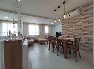 乌巴图巴Home Resort - Apto JPII48B Ubatuba的用餐室以及带桌椅的起居室。