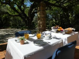 穆然飞鸟天堂庄园酒店的一张桌子,上面有白色的桌布,上面有食物和饮料