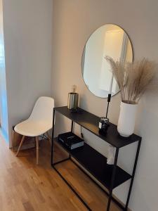 格里姆斯塔Koselig leilighet med balkong og sjøutsikt.的一张带镜子的桌子和一张白色的椅子
