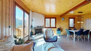 Charming chalet with a splendid view of the Valais mountains的一间客厅,客厅内配有桌椅