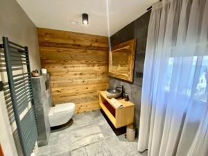 捷克布杰约维采Chalupa pod Ořechem的浴室配有白色卫生间和木墙