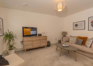 奥赫特拉德Arranmore House的带沙发和平面电视的客厅