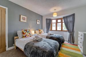 伍斯特Guest Homes - Severn Swans House的一间卧室设有两张床和窗户。
