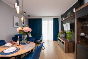 格但斯克Maya's Flats & Resorts 50 - Aura 40的客厅配有桌子和蓝色椅子