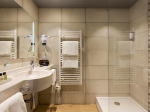 布雷西尔Hôtel Roi Soleil Prestige Plaisir的一间带水槽和淋浴的浴室